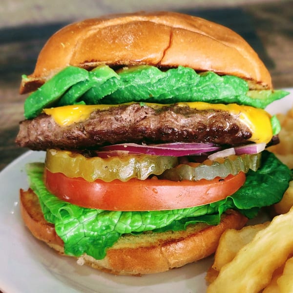 A Springdale Cafe cheeseburger with lettuce, tomato, pickles, and onions, served with fries.